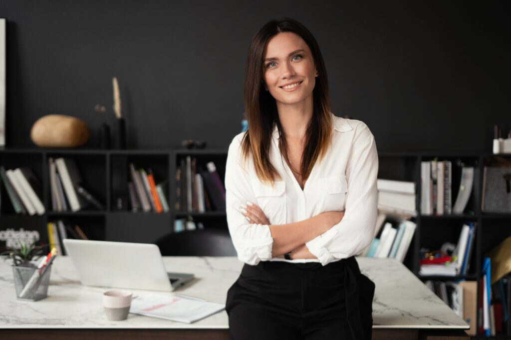 Confident woman standing at workplace looking at camera in office, portrait.
