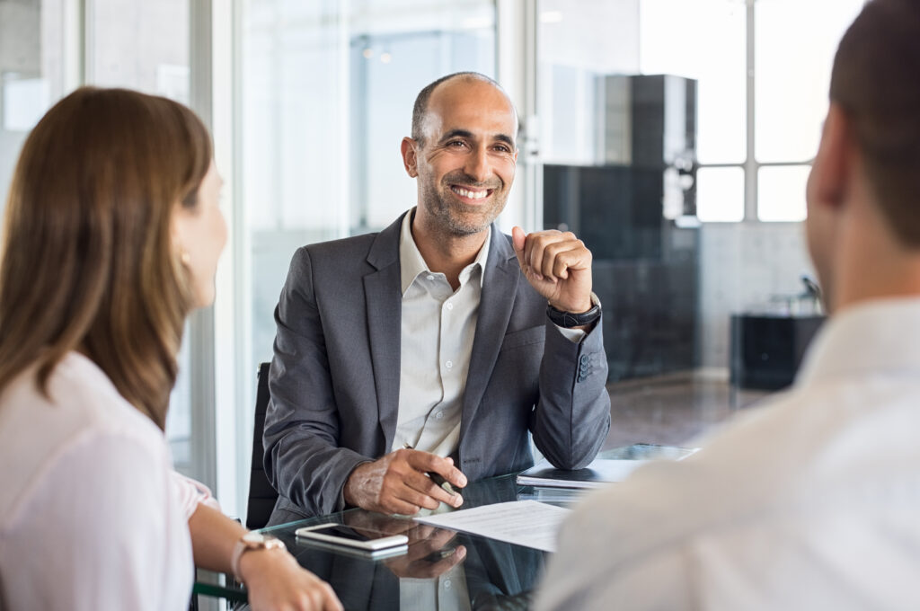 Mature consultant in meeting sitting with clients.